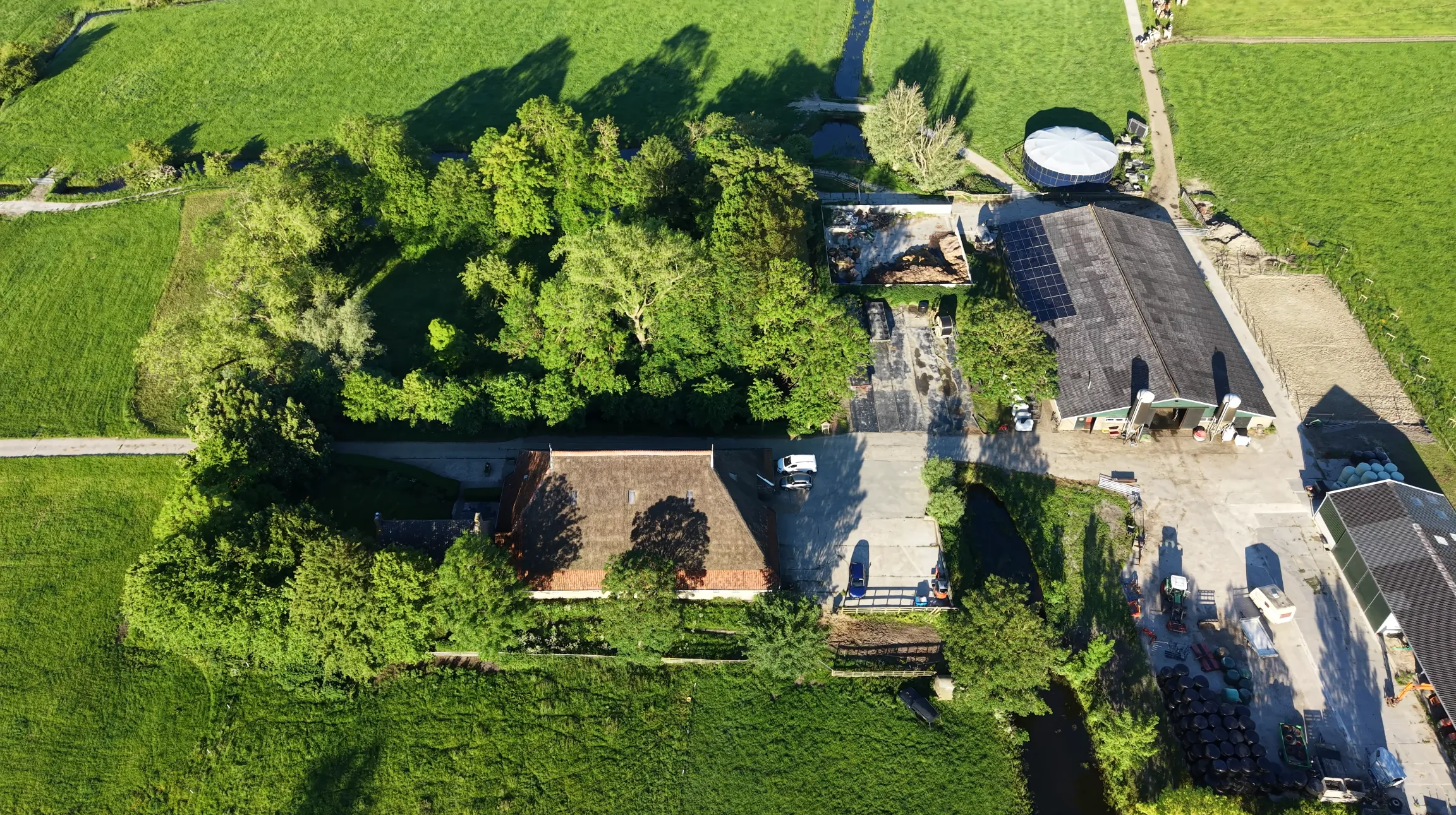 Het erf met de kop-hals-rompboerderij en de schuren, recht van boven gezien