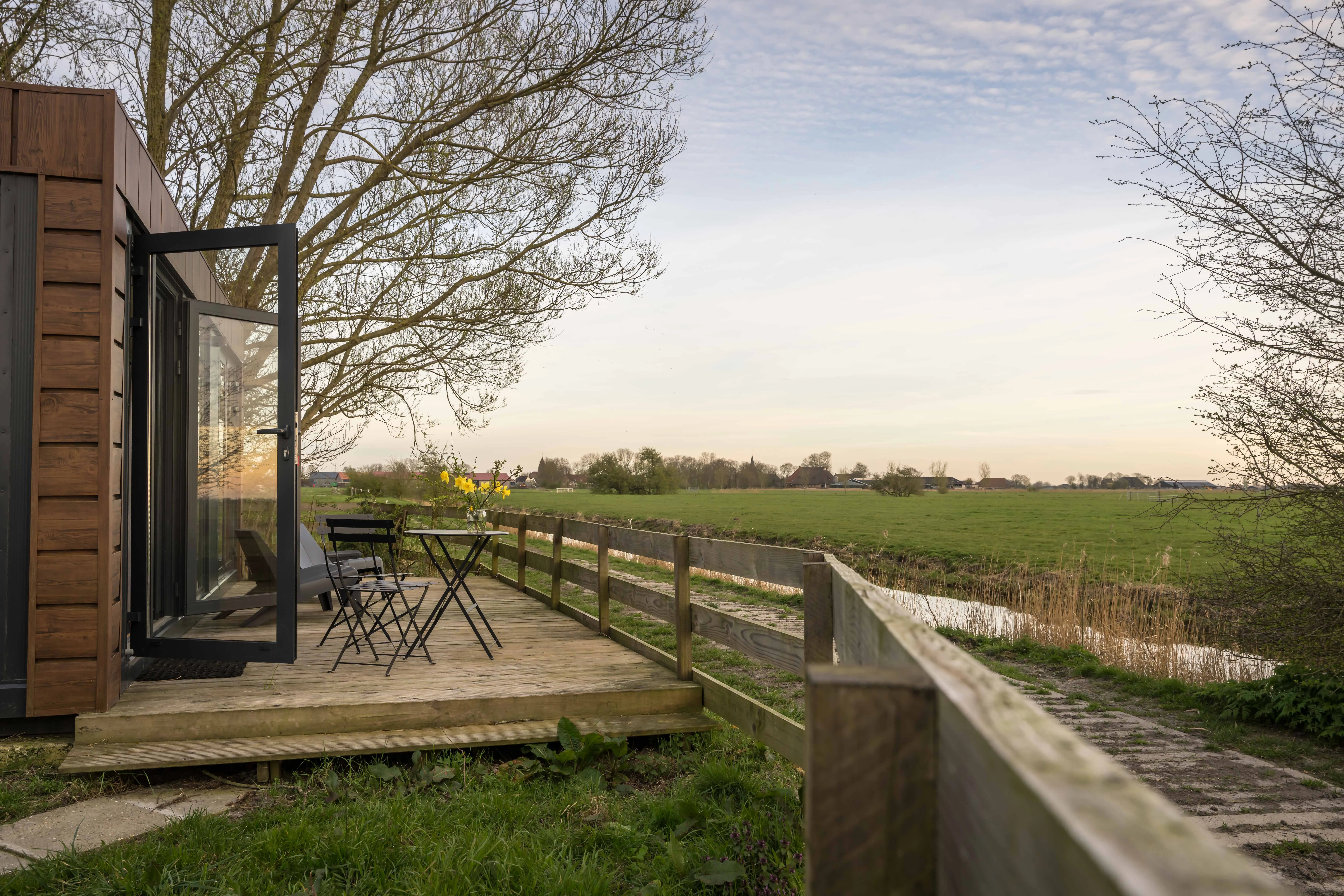 Het terras van het natuurhuisje aan de rand van de weilanden